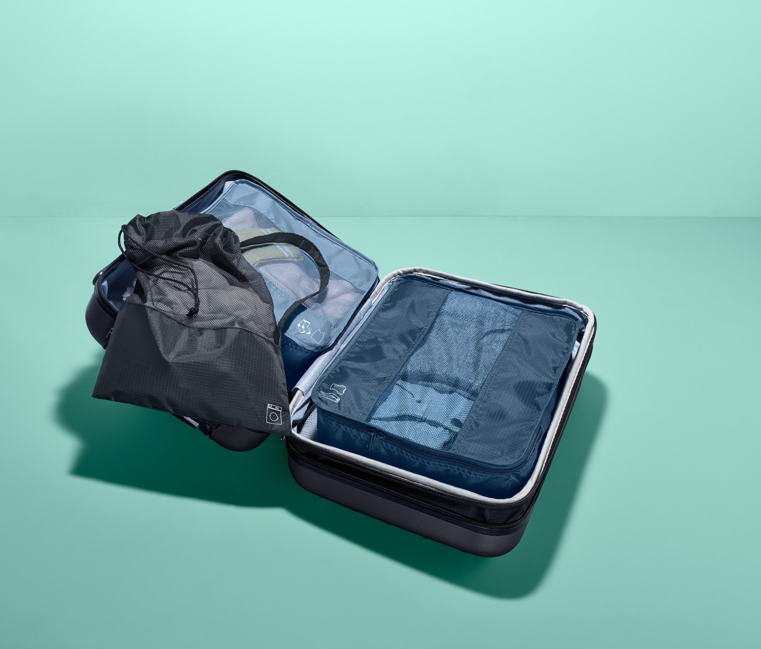 Tri cestovné úložné tašky v kufri.