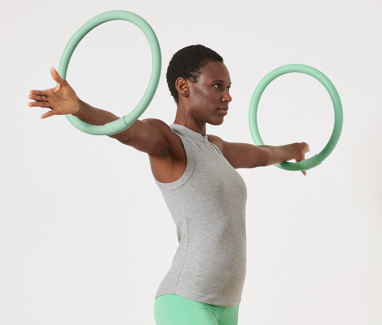 Žena cvičí s 2 kruhmi na precvičovanie rúk.