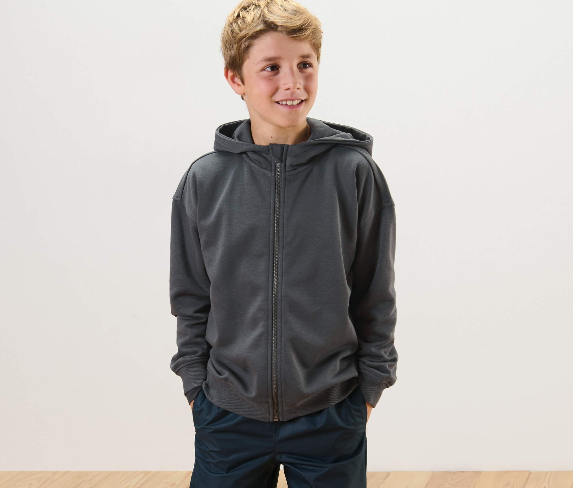 Chlapec má na sebe detskú mikinu s počesanou vnútornou stranou.