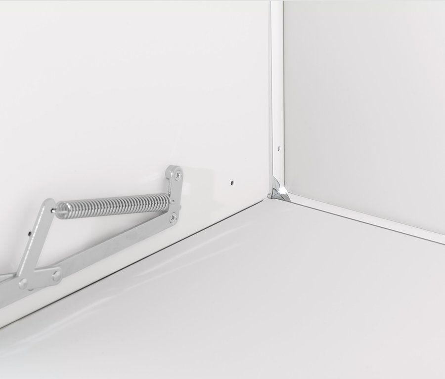 Detail bielej skrinky CN3 s kovovým mechanizmom výklopných dvierok.