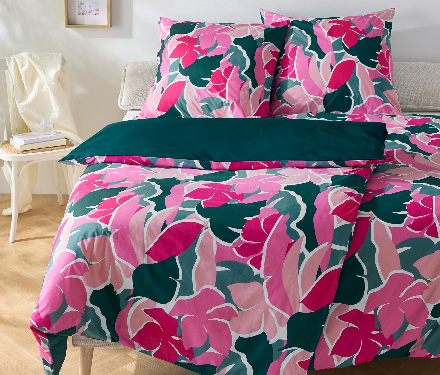 Kvetinové perkálové obliečky, dve štandardné veľkosti a jedna nadmerná veľkosť, ležia na posteli.