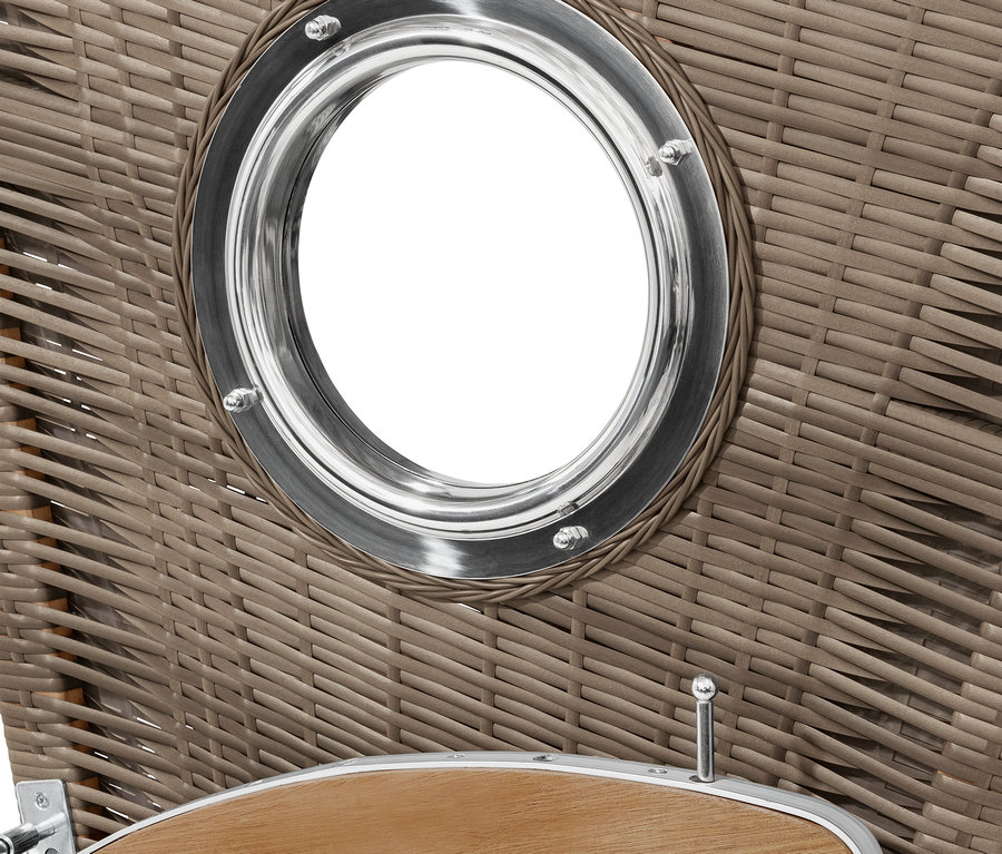 Detail prúteného plážového koša s okrúhlym okienkom s kovovým rámom.