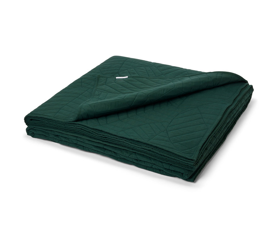 Tmavozelená prešívaná prikrývka na posteľ, 230 x 250 cm, zložená na hromade.