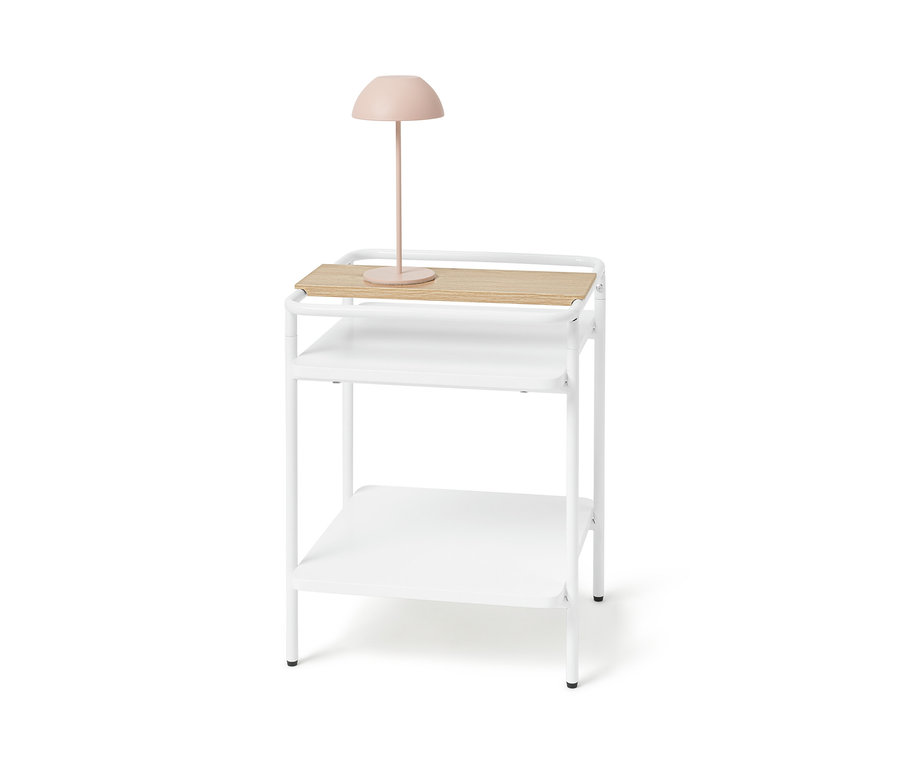 Biely odkladací stolík so svetlým dreveným povrchom a ružovou lampou.