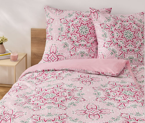 Ružové obliečky z mikrovlákna štandardnej veľkosti s kvetinovým vzorom na posteli.
