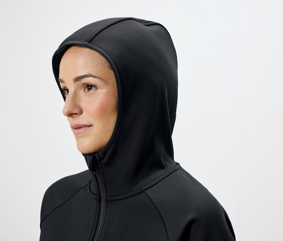 Žena s hnedými vlasmi má na sebe čiernu mikinu s kapucňou.