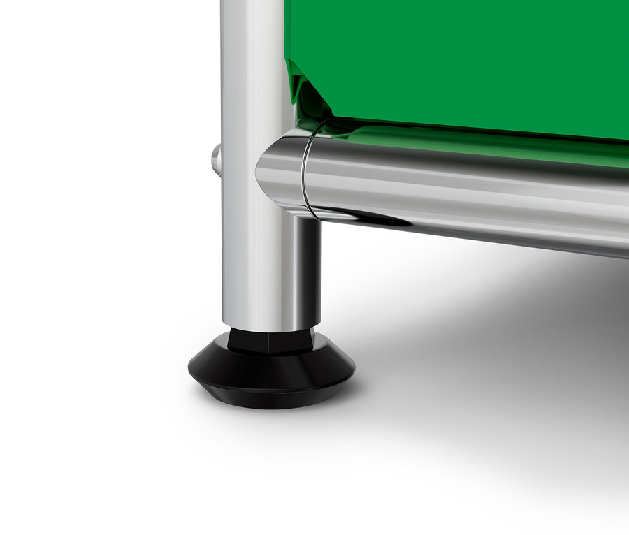 Detail chrómovej nohy s čiernou pätkou a zelenou doskou na bielom pozadí.