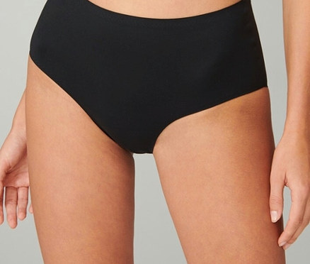 Detailný záber ženy v čiernych bikinových nohavičkách s vysokým pásom.