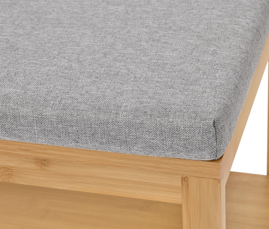 Detailný záber na stoličku so sivou látkou a svetlým dreveným rámom.