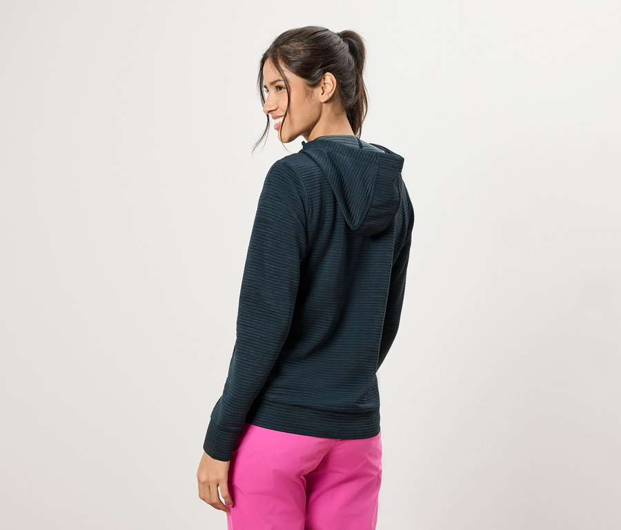 Žena zozadu, má na sebe tmavozelenú mikinu s kapucňou a ružové nohavice.