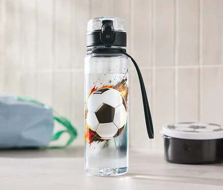 Fľaša na vodu s futbalovým motívom stojí na stole.