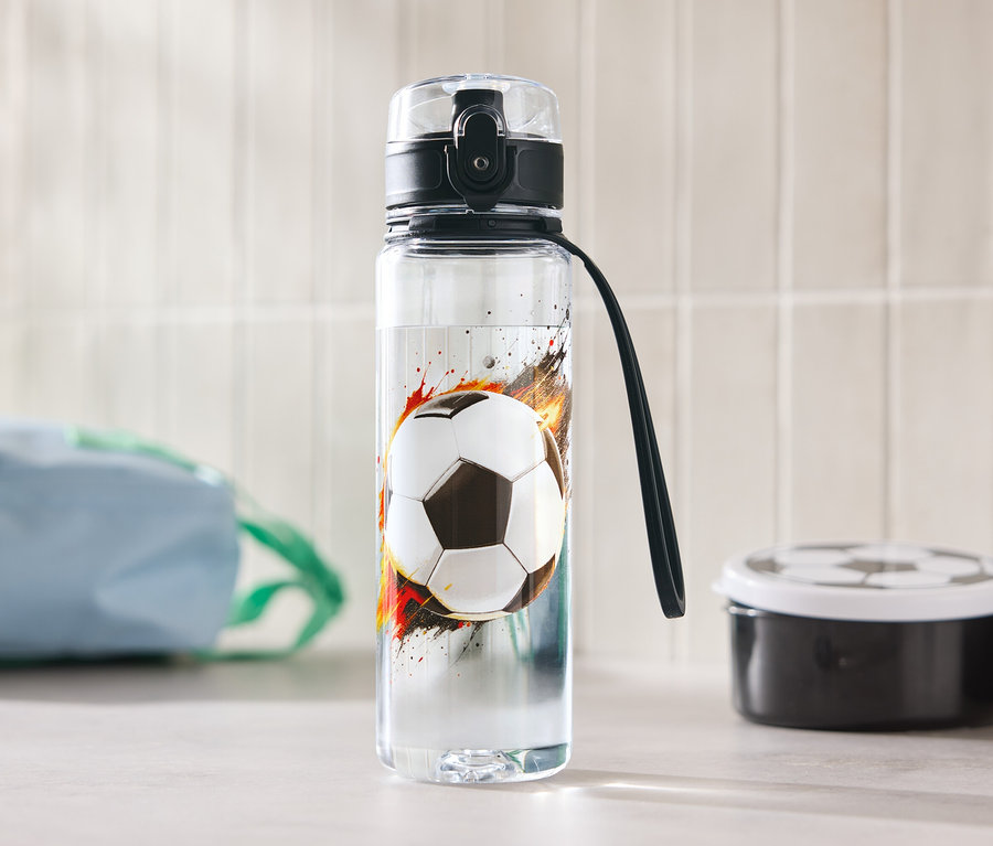 Fľaša na vodu s futbalovým motívom stojí na stole.