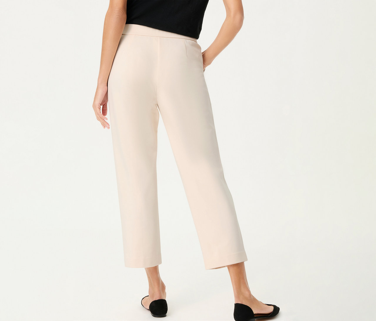 Pohľad zozadu na ženu v ľanových nohaviciach Olsen a čiernych topánkach na bielom pozadí.