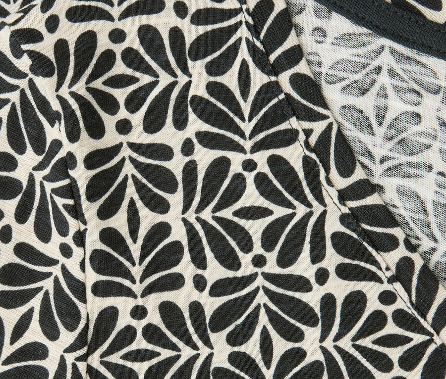 Detail trička Street One s čiernym vzorom listov a bodiek a véčkovým výstrihom.