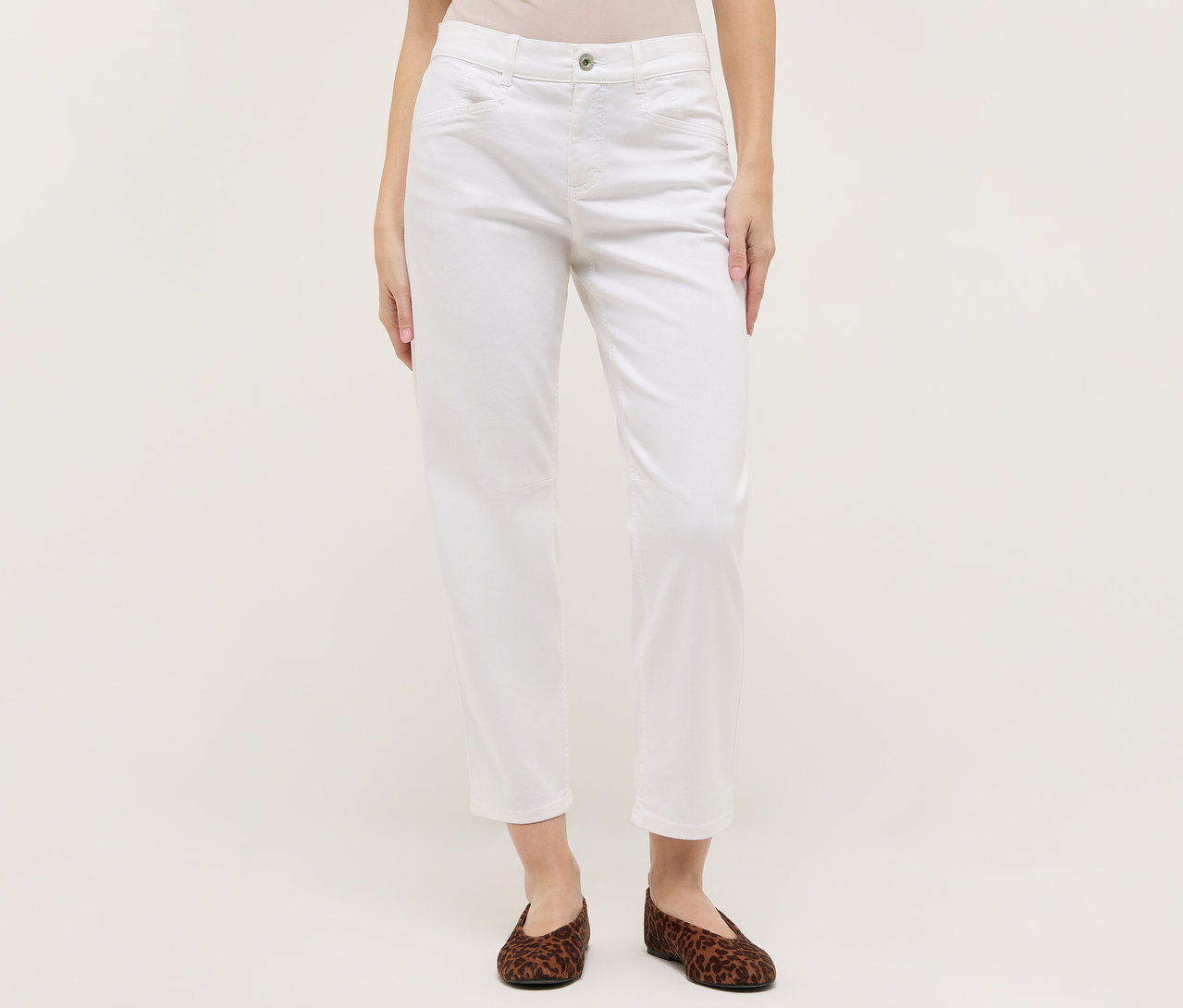 Žena má na sebe biele nohavice Angels Denim »Evy Cool« O-Shape a hnedé balerínky so zvieracou potlačou na svetlom pozadí.