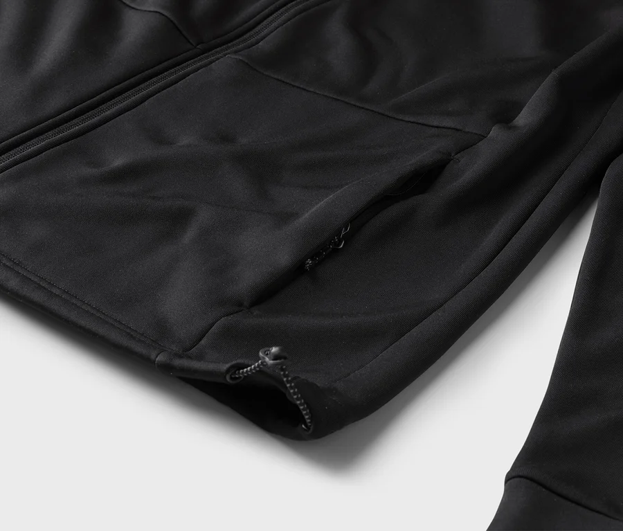 Detail čiernej tréningovej bundy so zipsom a vreckom na zips na rukáve.