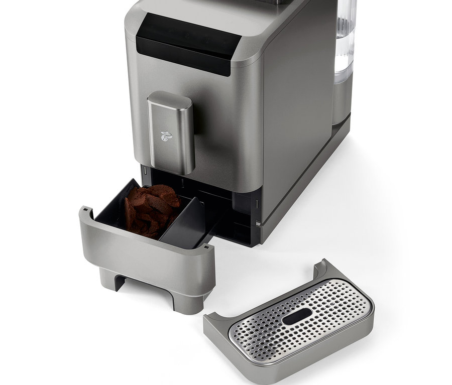Detail plnoautomatického kávovaru »Esperto2 Caffè« v Titanium Silver farbe s vybratou nádobou na kávovú usadeninu a odkvapkávacou miskou.