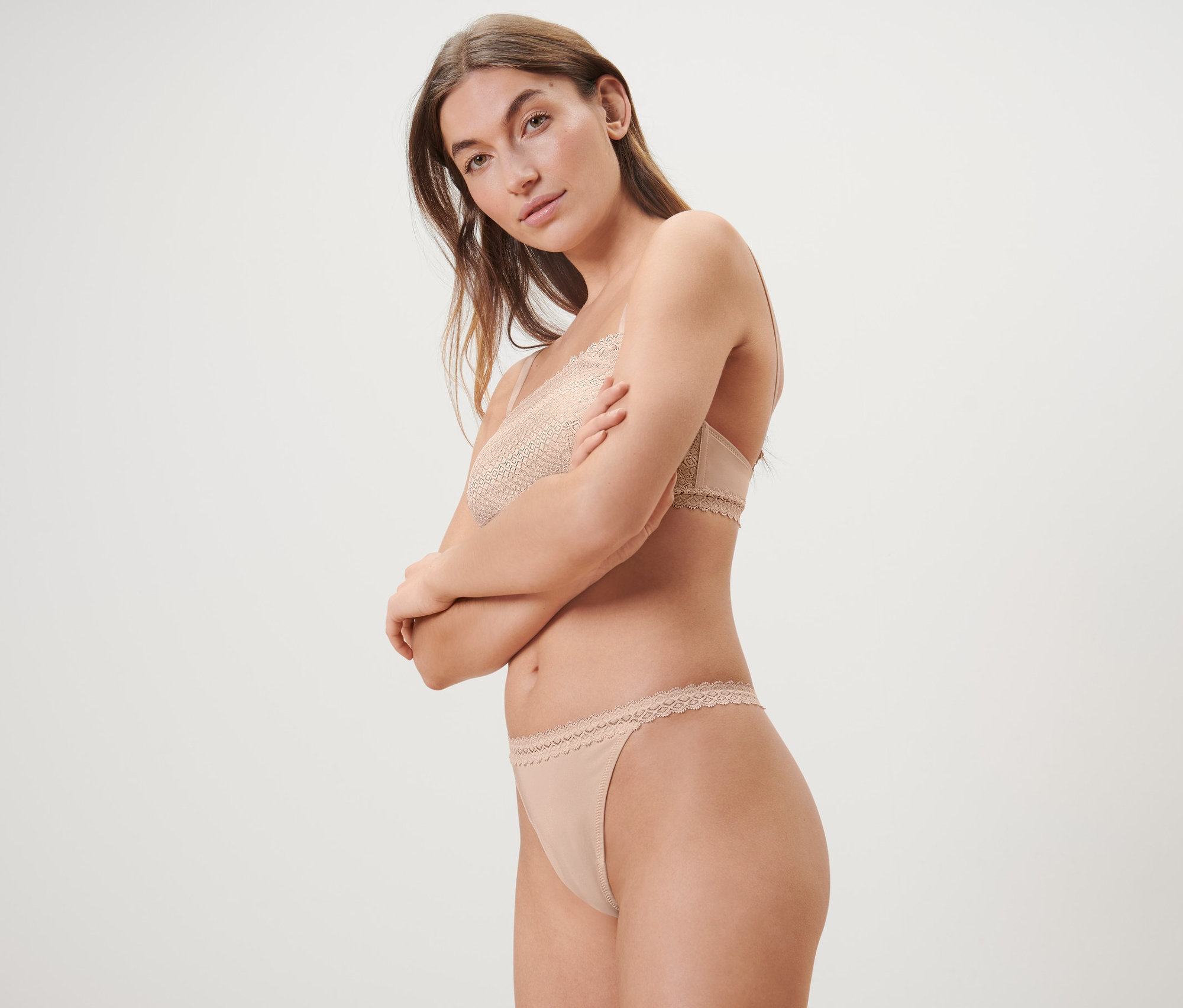 Žena pózuje v béžovej čipkovanej podprsenke a nohavičkách tangá, 5 ks.