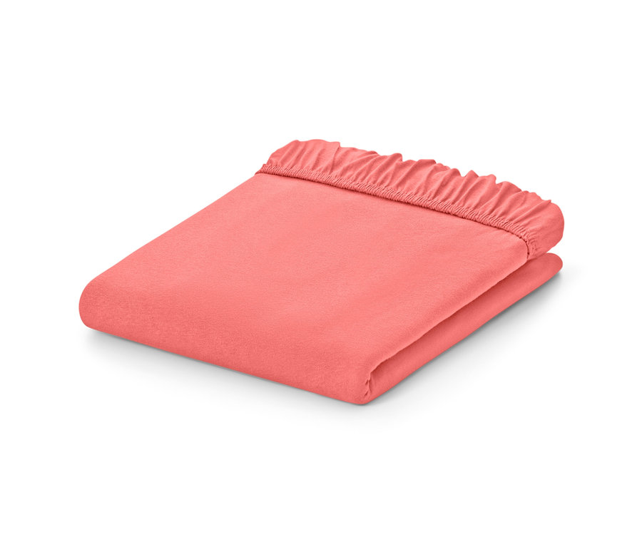 Zložené papájové džersejové napínacie plachty rôznych veľkostí na bielom pozadí.