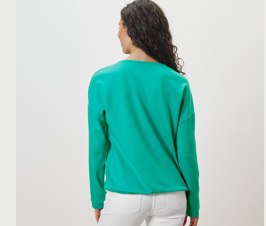 Pohľad zozadu na ženu s tmavými vlasmi v akvamarínovej mikine.