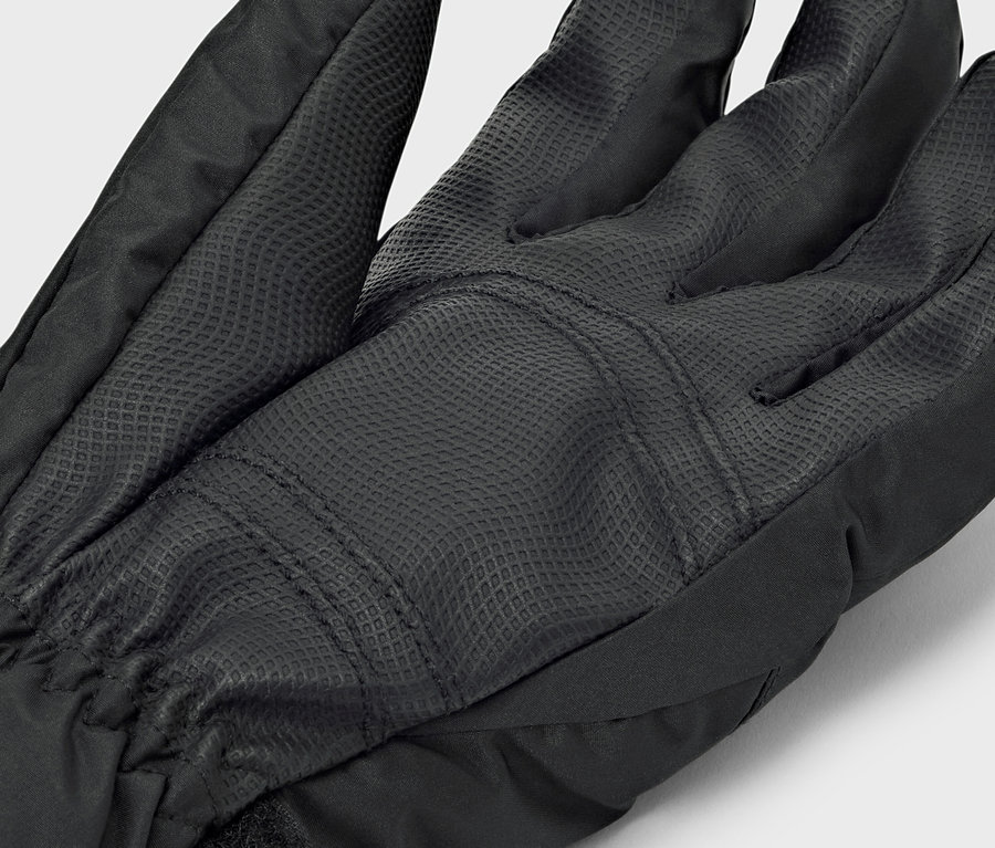 Detail čiernej rukavice s textúrovanou dlaňou.
