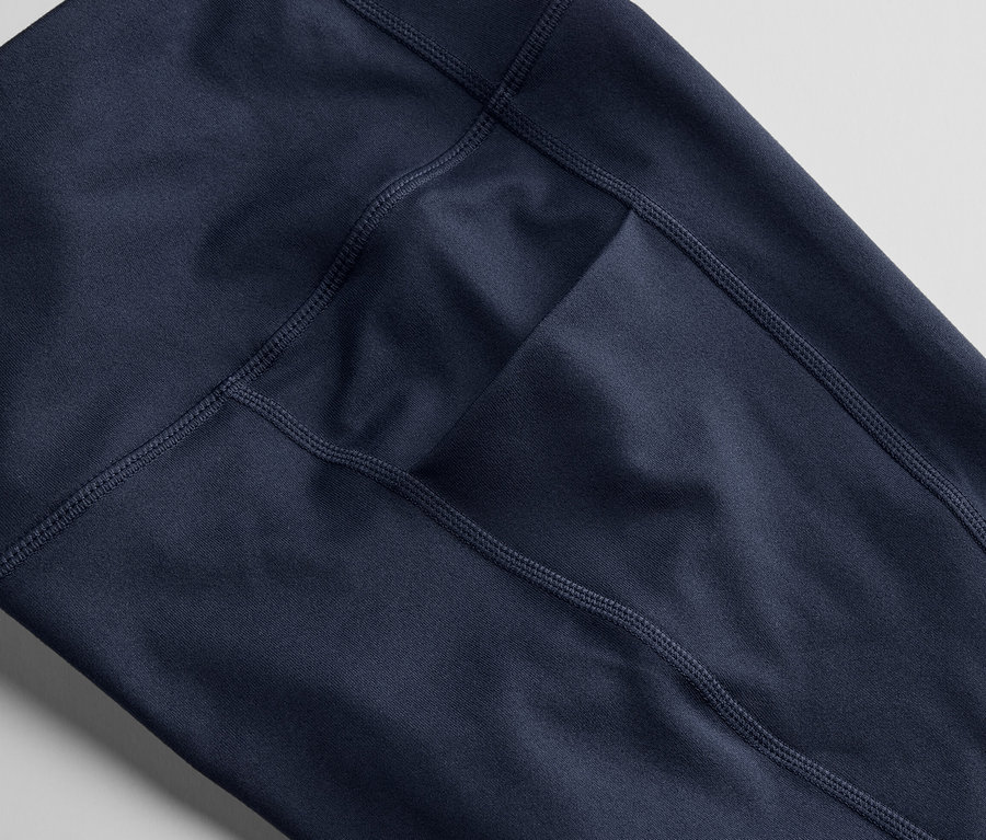 Detailný záber na 3/4 športové legínsy tmavomodrej farby s vreckom.