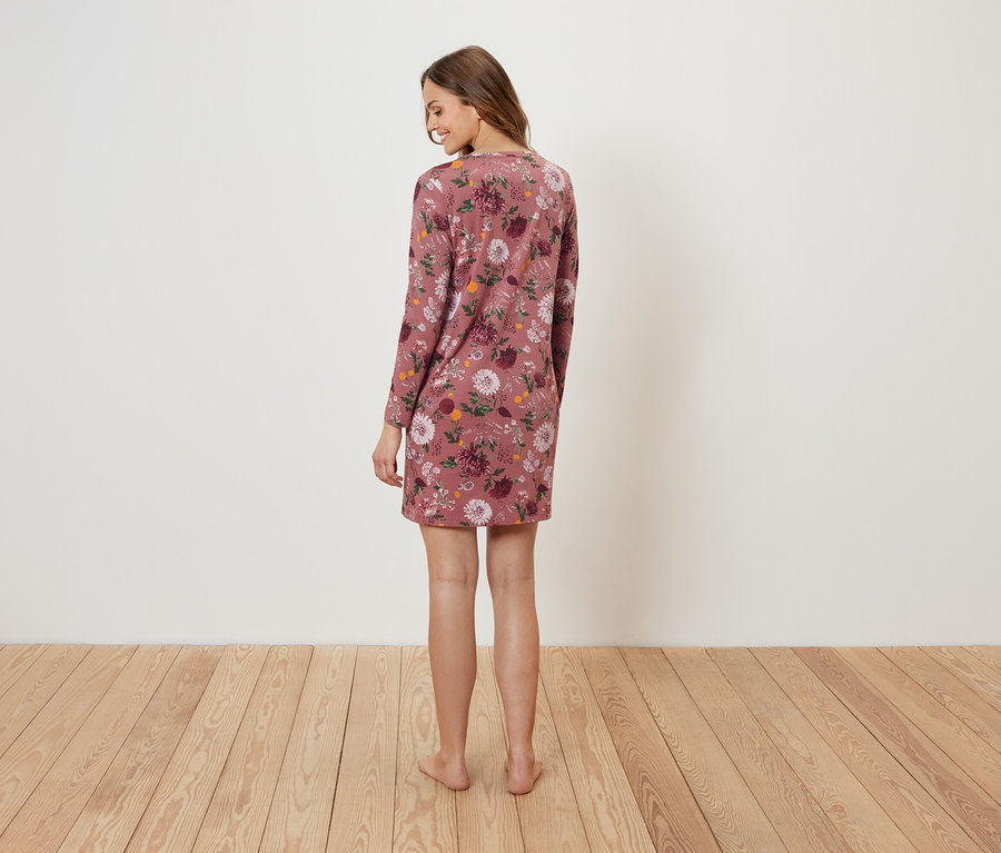 Žena stojí chrbtom a má na sebe kvetinové šaty.