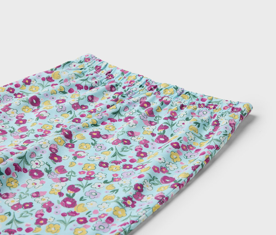 Detail svetlomodrých nohavíc s kvetinovým vzorom a elastickým pásom.