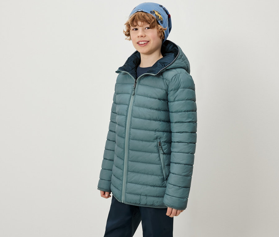 Chlapec má na sebe 2-v-1 Kinder Softshell a Steppjacke a modrú čiapku.