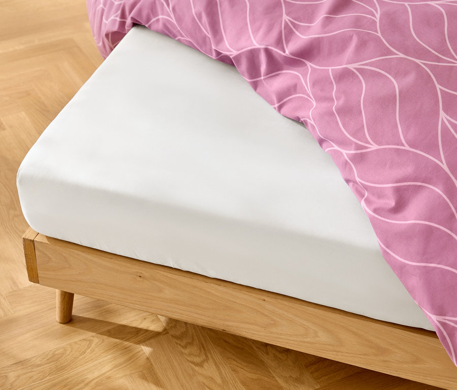 Biele napínacie plachty na drevenom ráme postele s ružovou posteľnou bielizňou s bielym vzorom.