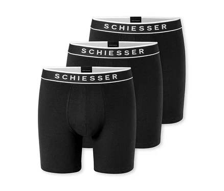Tri čierne boxerky, mierne za sebou usporiadané, s bielym pásom a logom „SCHIESSER“.