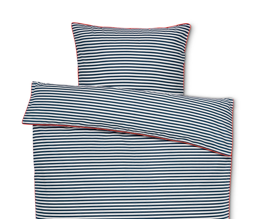 Pohľad zhora na rozložené posteľné obliečky renforcé s modrými a bielymi pruhmi a červeným lemom.