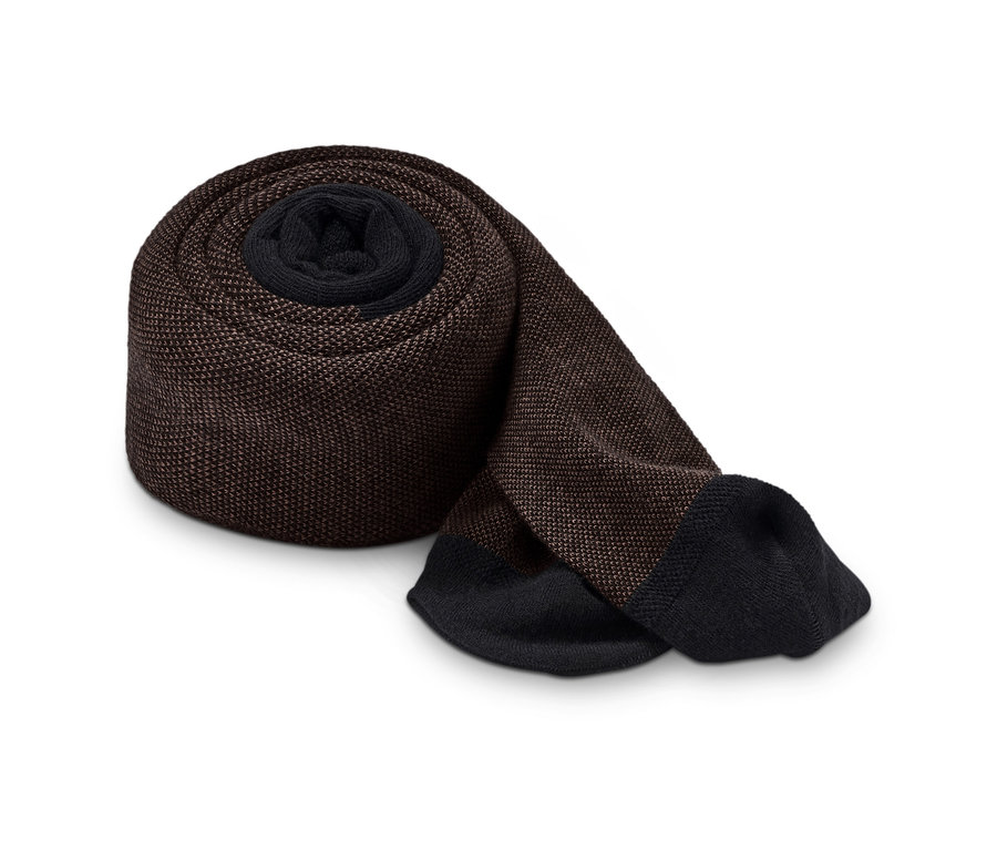 Hnedé štruktúrované pančuchové nohavice zrolované na bielom pozadí.