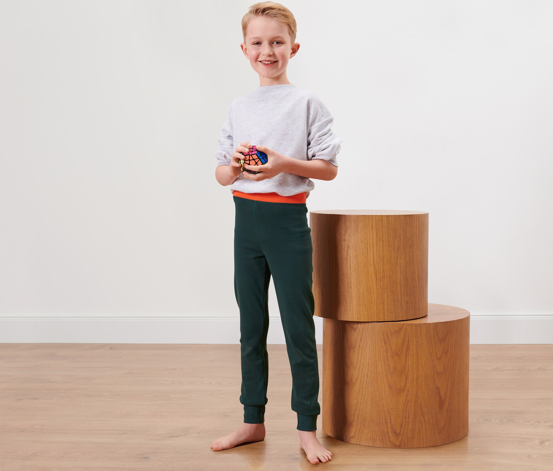 Chlapec drží Rubikovu kocku a má na sebe detské zimné spodky, 2 ks.
