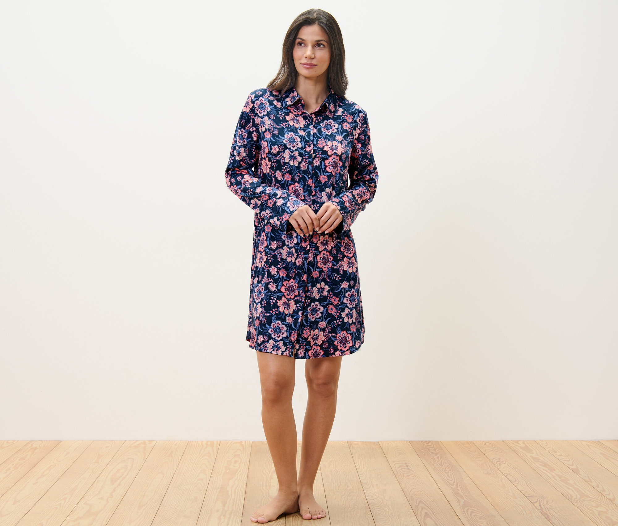 Žena stojí a má na sebe tkanú nočnú košeľu s kvetinovým vzorom.