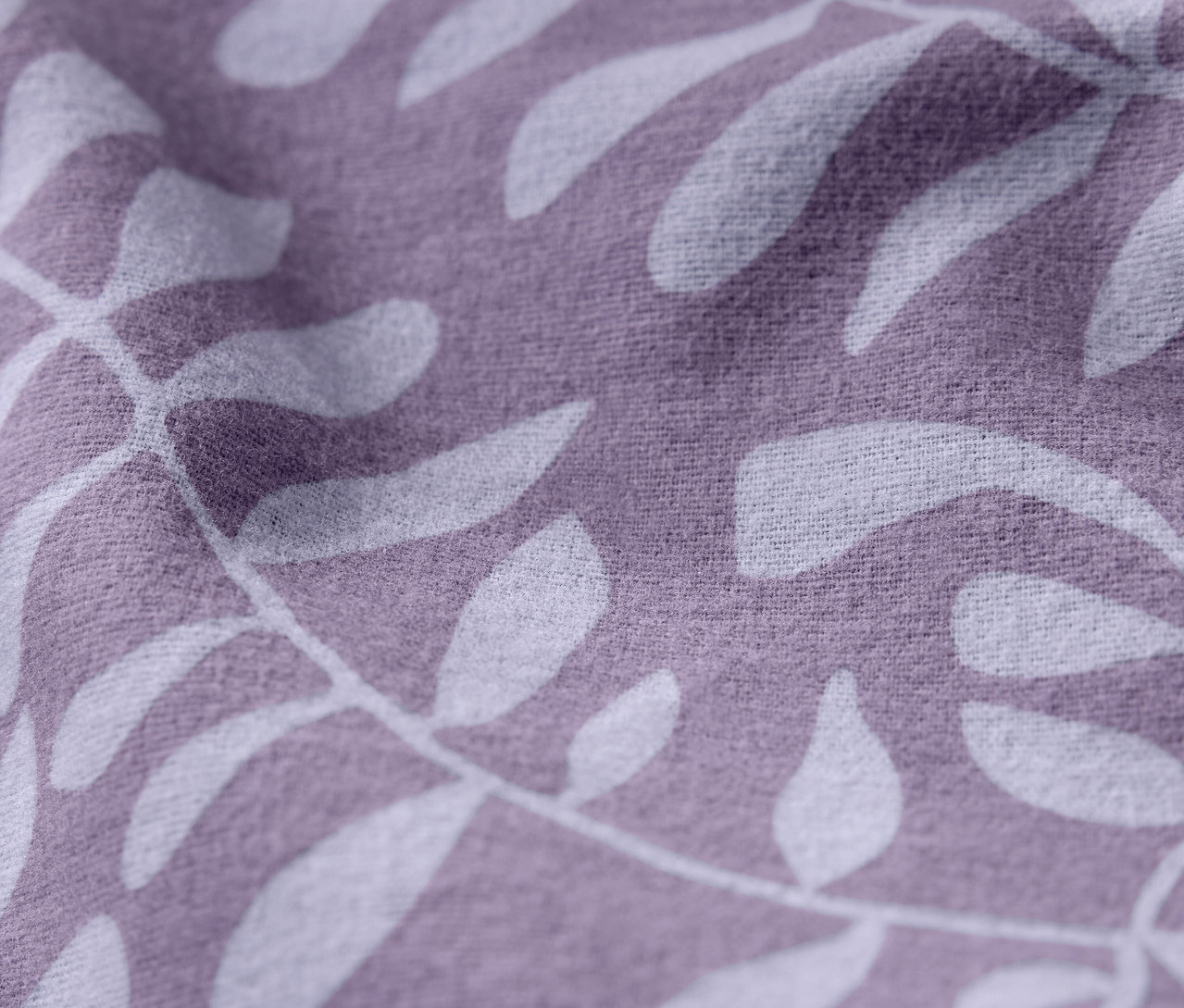 Detailný záber fialovej látky s bielym vzorom listov.