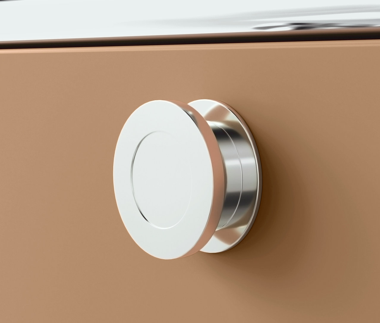 Detail striebornej okrúhlej úchytky na hnedej zásuvke.