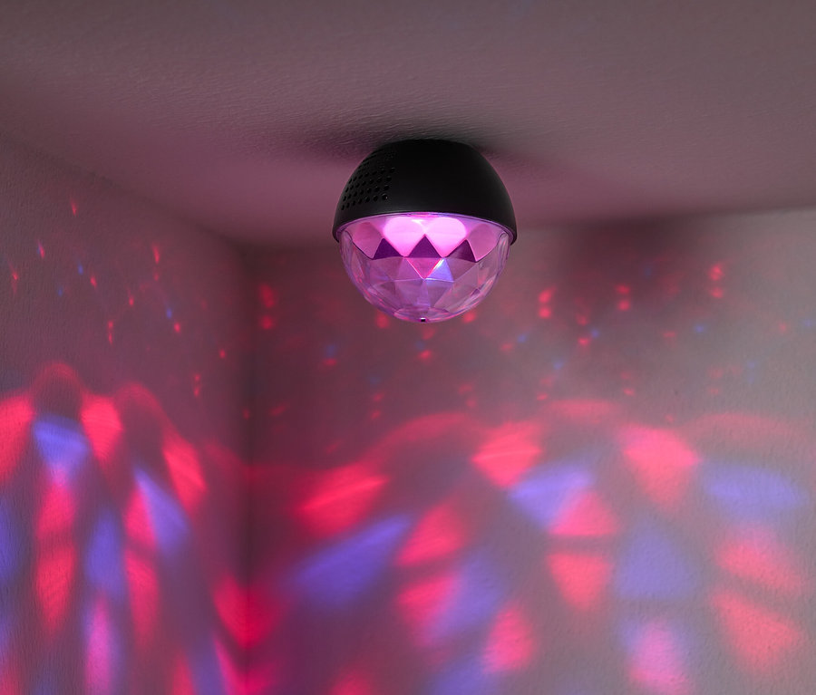 Na strope je pripevnená disco guľa, ktorá vrhá na steny miestnosti červené a modré svetlá.