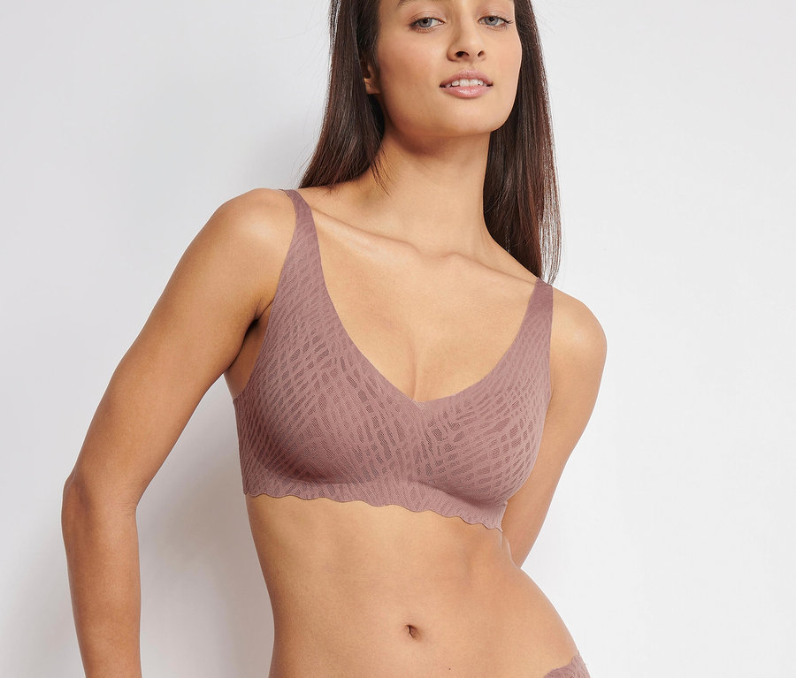 Žena má na sebe mäkkú podprsenku sloggi ZERO Feel Bliss Soft Bra, cacao a nohavičky.
