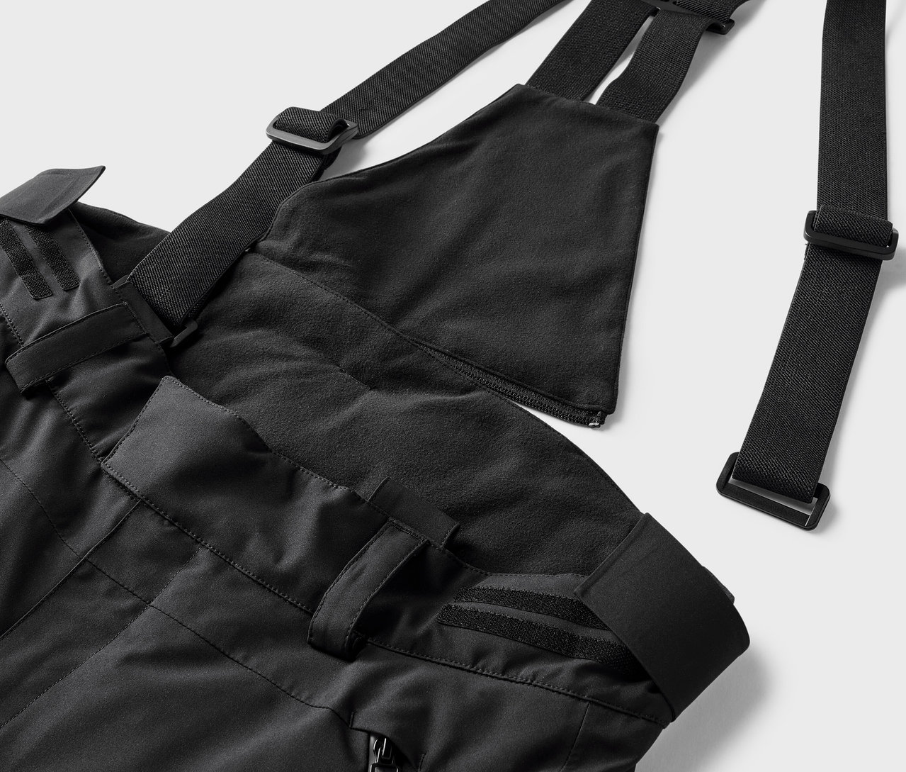 Čierne lyžiarske nohavice s podbradníkom a nastaviteľnými popruhmi.