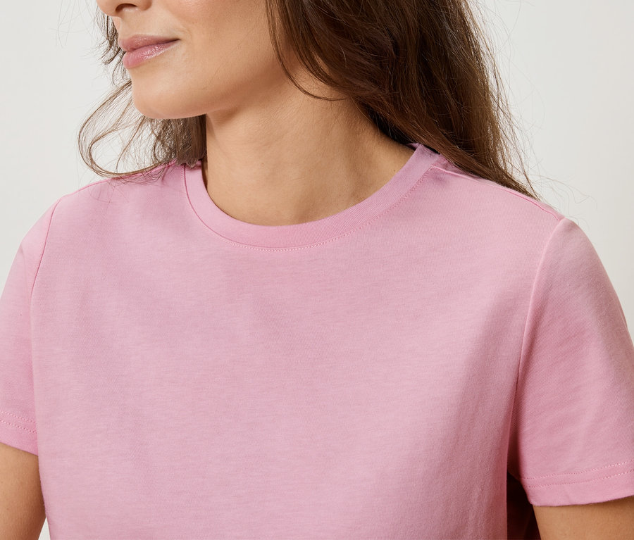 Detailný záber ženy v ružovom tričku.