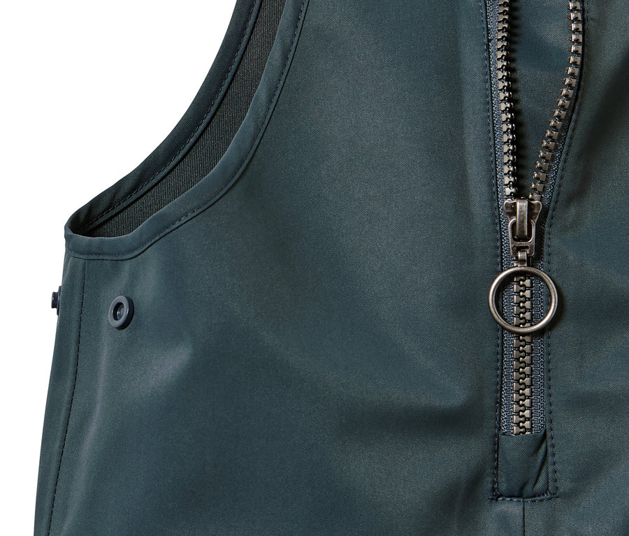 Detail detských nohavíc do dažďa so zipsom a gombíkom.