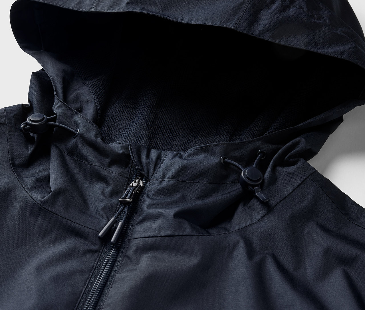 Detail bundy do dažďa, námornícka modrá, s kapucňou a zipsom.