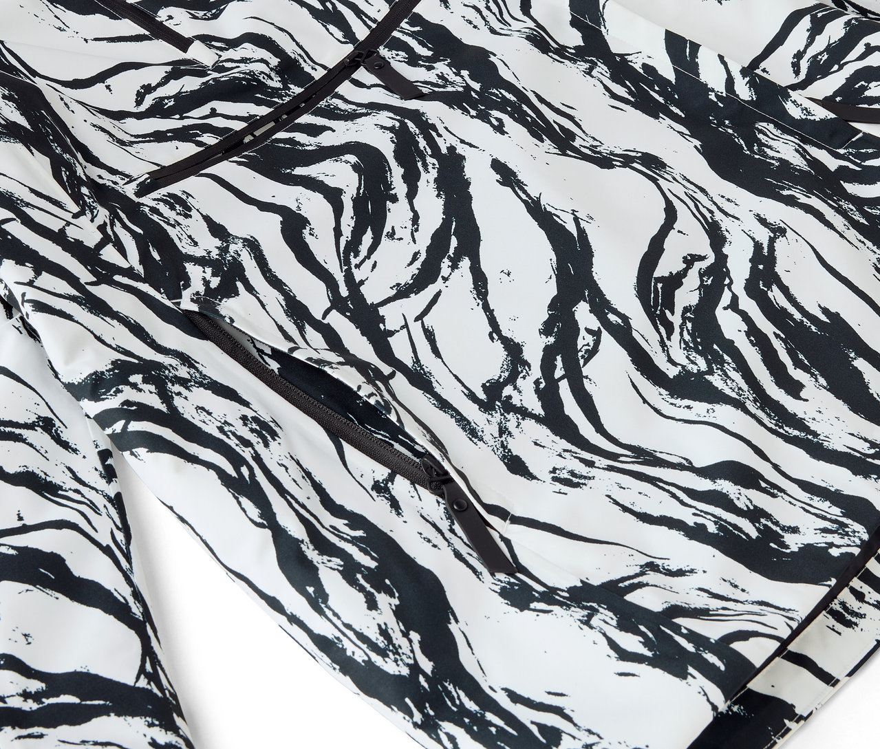 Detail bieleho pyžama s čiernou abstraktnou potlačou a lemovaním.