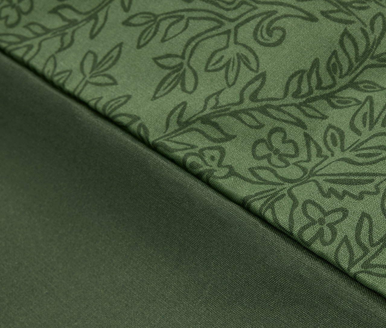Detail zelenej látky s kvetinovým vzorom a hladkej zelenej látky.