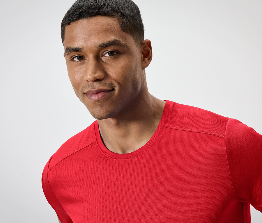 Portrét muža s krátkymi vlasmi v červenom tričku.