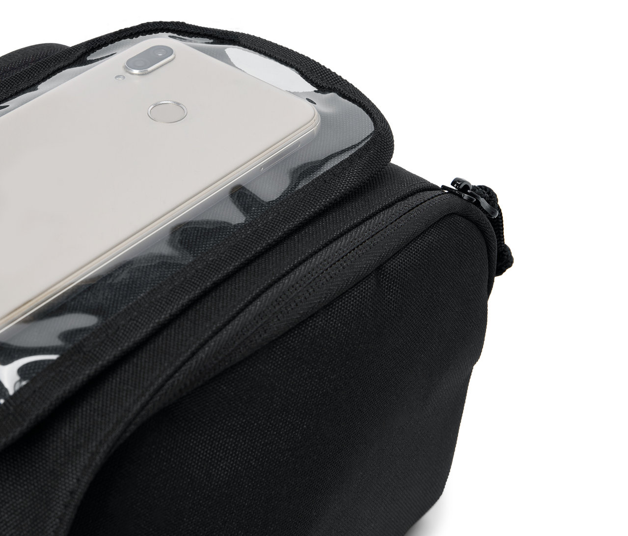 Strieborný smartfón leží v priehľadnom vrecku na čiernej taške.