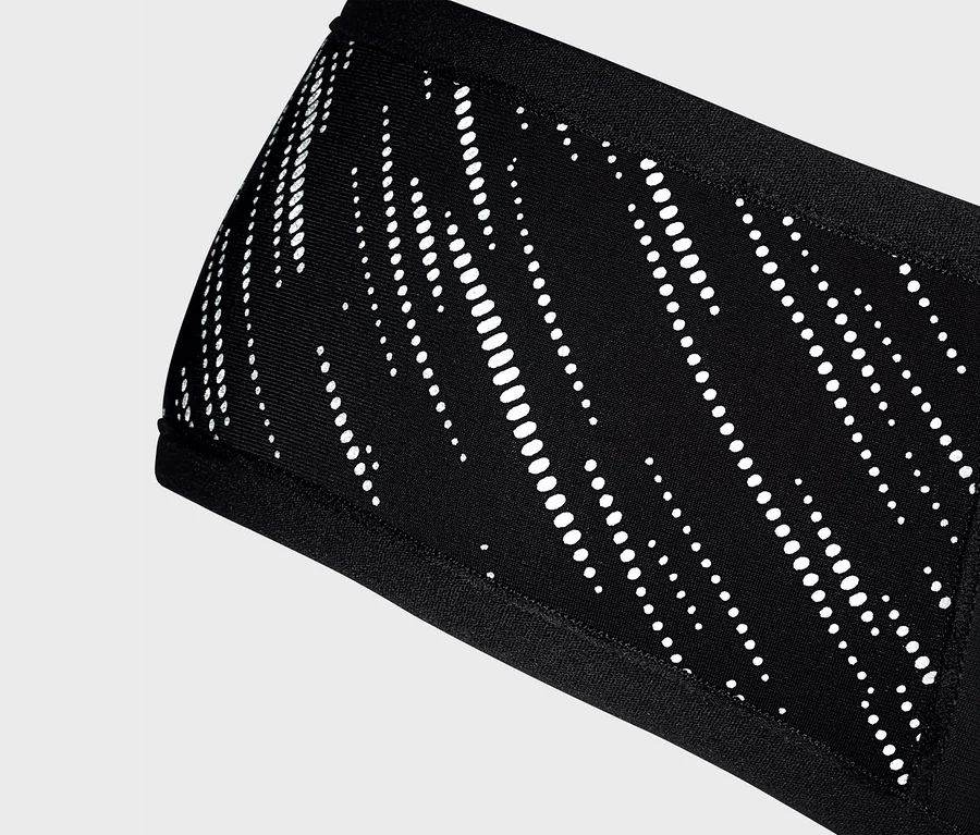 Detailný záber na čiernu čelenku Windprotection-Stirnband s bielym vzorom.