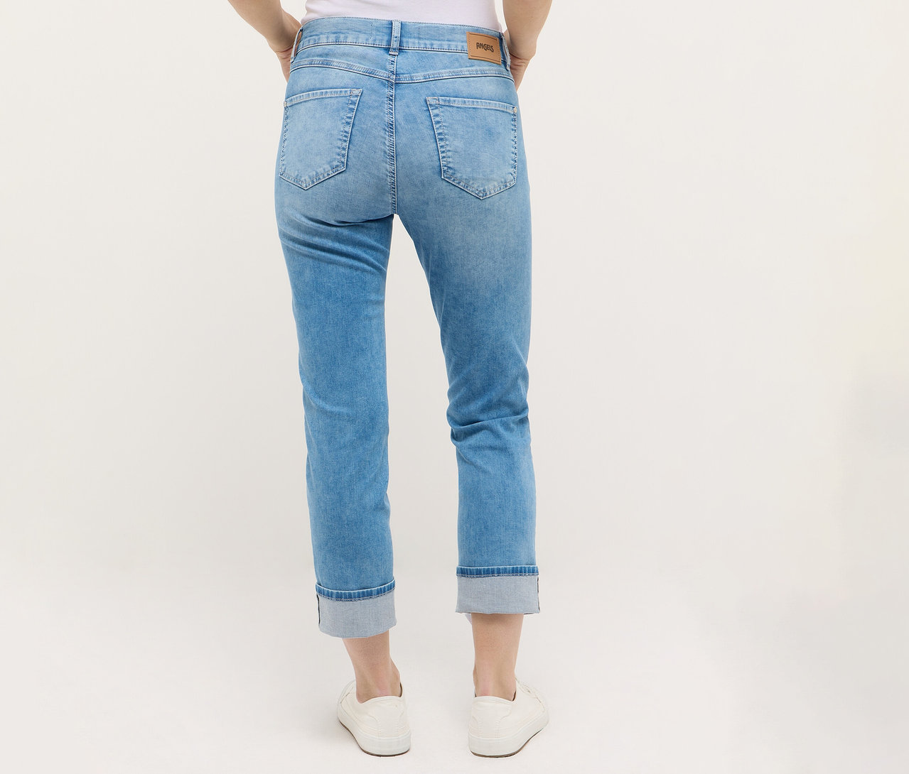 Osoba nosí Angels Denim »Cira Boho« džínsy a biele topánky.