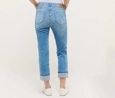 Osoba nosí Angels Denim »Cira Boho« džínsy a biele topánky.